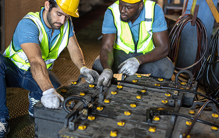 Technicians inspecting industrial batteries